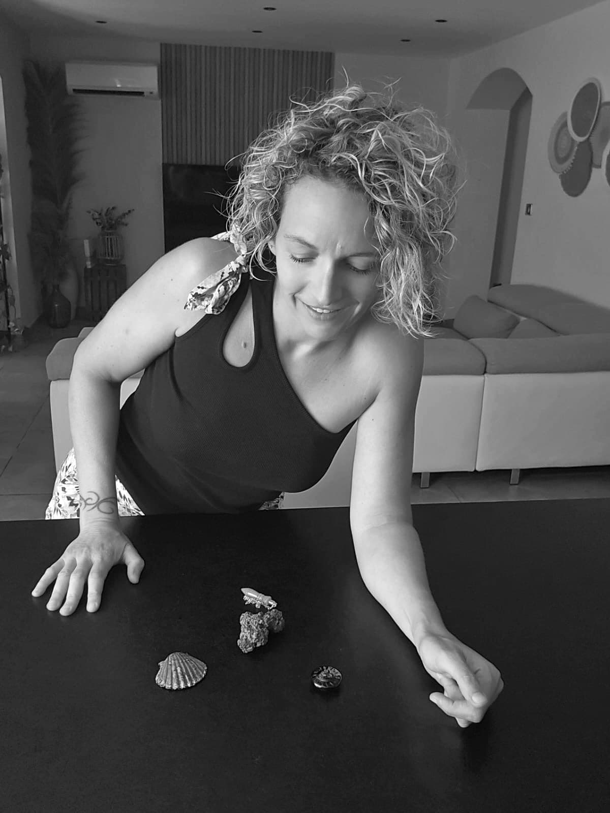 Johanna penchée sur une table, en train de disposer des objets pour une constellation.
